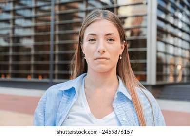 Close up individual portrait of a confident and formal teenage blonde woman with serious expression. Unsmiling real caucasian girl. Young female student looking at camera thinking and staring front - Powered by Shutterstock