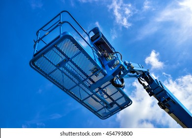 Close Up Of Industrial Boom Lift Basket Against Blue Sky.