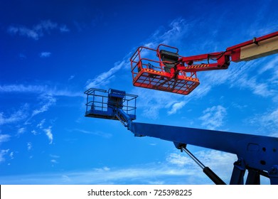 Close Up Of Industrial Boom Lift Basket Against A Blue Sky.