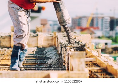 close up of industrial worker pouring cement or concrete with automatic pump tube