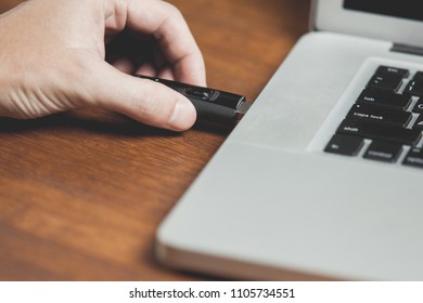 close up inserting USB 3.0 flash drive into laptop computer