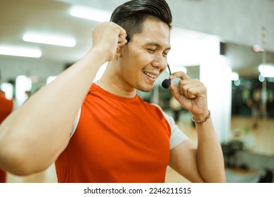 close up of instructor setting up wireless microphone getting ready before leading workout in fitness center - Powered by Shutterstock