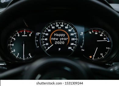 Close up Instrument automobile panel with Odometer, speedometer, tachometer, fuel level, which says Happy New Year 2020. The concept of the new year and Christmas in the automotive field