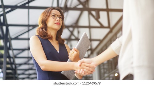 
close up investor businesswoman handshake with partner vendor,collaboration of two ceo leader hand shake for agreement or deal financial cooperative concept