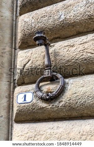 Close up of an iron ring (or hitching post) used in ancient times to tie horses and to hold fire lamps, on a wall of a medieval building in Florence city center, Tuscany region, Italy