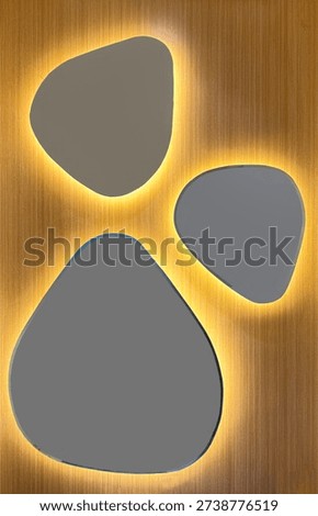 Close up irregular mirror shape resembling dogs paw with yellow backlights and wood background. Suitable for mirrors decorative panel, at toilet, or cute accessories.