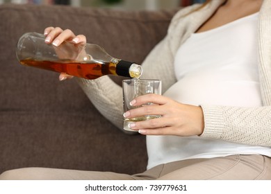 Close Up Of An Irresponsible Pregnant Woman Drinking Alcohol Sitting On A Couch At Home