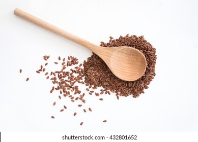 close up of isolated flax seed on white background - traditional wooden spoon - studio shot from above