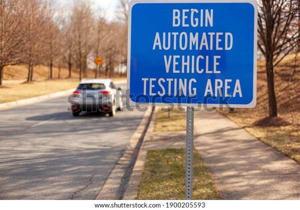 Close up isolated image of a road sign near\
Washington DC that says: Begin Automated Vehicle Testing Area. This\
is one of the few spots in US where self driving cars are tested\
for safety.