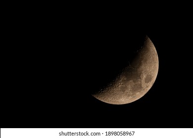 Close up isolated super telephoto image of the moon at night sky during the waxing crescent phase. Details of the craters and the sea of tranquility is visible. The sky is clear.