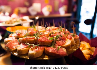 Close Up Of Italian Style Aperitivo Food, Small Bruschette With Salami To Celebrate The Happy Hour Inside Bar 