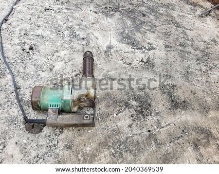 close up jack hammer lying on the chipped concrete floor