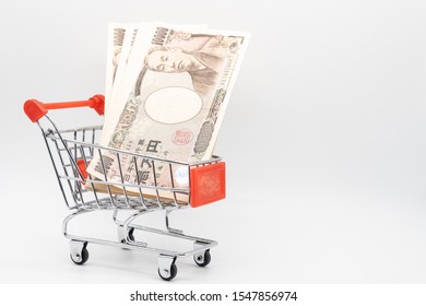 Close Up Japanese Currency Yen Money Banknote In Small Shopping Trolley . Background Concept For Japan  Economy And Online Market.