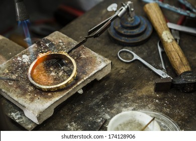 Close up of Jeweler crafting golden bracelet with flame torch. - Powered by Shutterstock