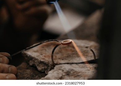 Close up of Jeweler crafting golden bracelet with flame torch. - Shutterstock ID 2318027953