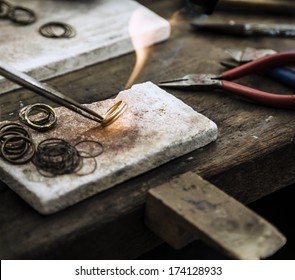 Close up of Jeweler crafting golden rings with flame torch. - Powered by Shutterstock