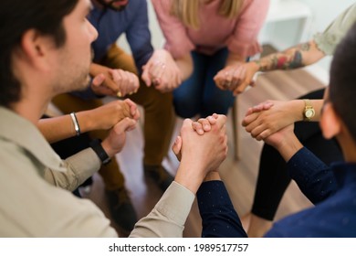 Close Up Of The Joined Hands Of An AA Group. High Angle Of Young People Holding Hands And Telling Each Other Words Of Encouragement And Support