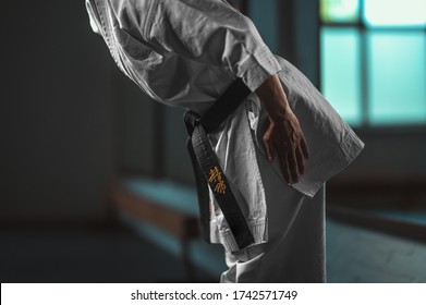 Close Up Karate girl with black belt displaying respect - on belt Kaishin wich means "Open Mind" - Powered by Shutterstock