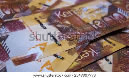 close up of Kenyan shilling notes spread on table. Paper money currency scattered on surface as background