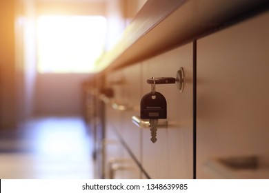 Close Up Key Locked On Filing Cabinet Drawer Desk Furniture In Office Building With Sun Light From Window.