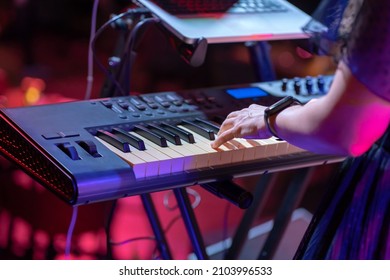 Close up of a keyboardist musician at work at a concert. Keyboardist play keyboard on stage. - Shutterstock ID 2103996533