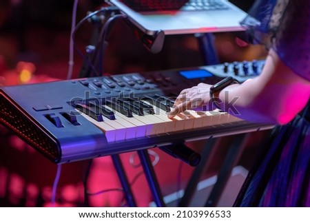 Close up of a keyboardist musician at work at a concert. Keyboardist play keyboard on stage.