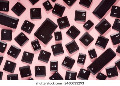 Close up of the keys of an old keyboard laptop on a pink table