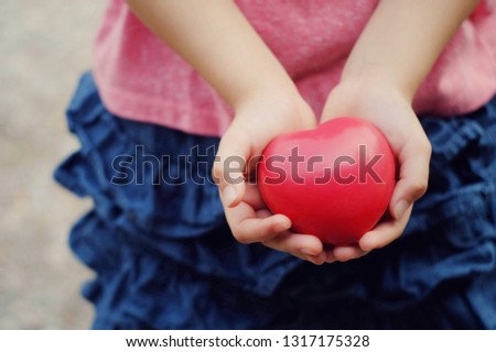 close up kid hand holding small red heart, happy venlentines, world health day, medical and healthcare business technology concept