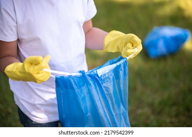 Close Up Of A Kid Holding A Plastic Bag For Garbage