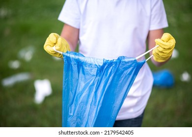 Close Up Of A Kid Holding A Plastic Bag For Garbage