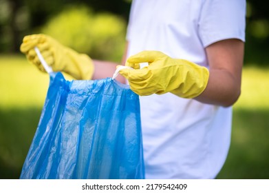 Close Up Of A Kid Holding A Plastic Bag For Garbage