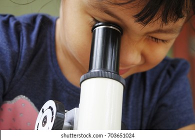 Close Up Kid Looking Through Microscope. Experiment In Plant Laboratory At Home