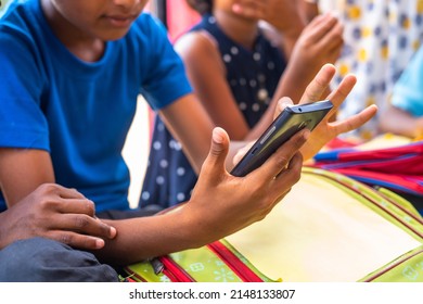 Close Up Of Kids Hands Busy Using Mobile Phone While Sitting At School Corridor During Break - Concept Of Technology, Social Media And Smartphone Addiction