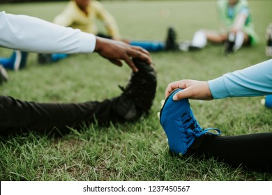 Close up of kids stretching on the field - Powered by Shutterstock