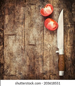 Close up knife and tomato on wooden table