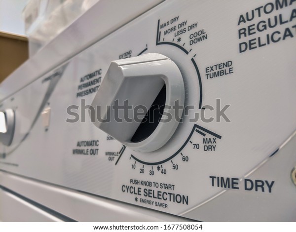 Close up\
of a knob on a clothing dryer control\
panel