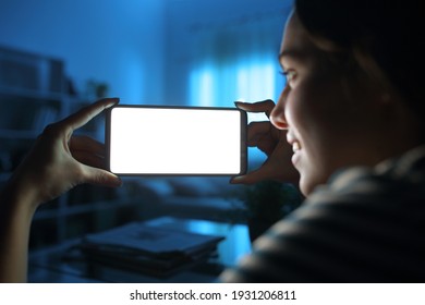 Close Up Of A Lady Hands Showing And Watching Horizontal Smart Phone Blank Screen In The Night At Home