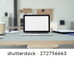 Close up Laptop Computer on Top of Office Table of a Businessman with Empty White Screen, Emphasizing Copy Space.