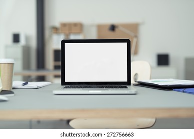 Close up Laptop Computer on Top of Office Table of a Businessman with Empty White Screen, Emphasizing Copy Space.