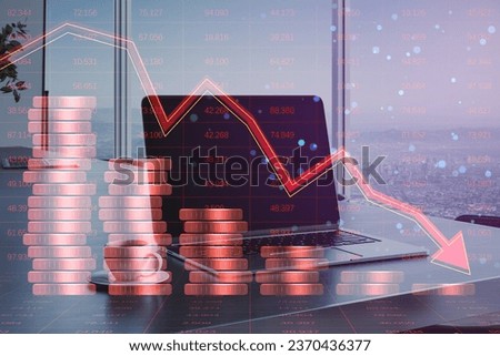 Close up of laptop at modern office workplace with creative forex chart hologram with declining stacked coins on blurry background. Financial recession, plummeting trade concept. Double exposure