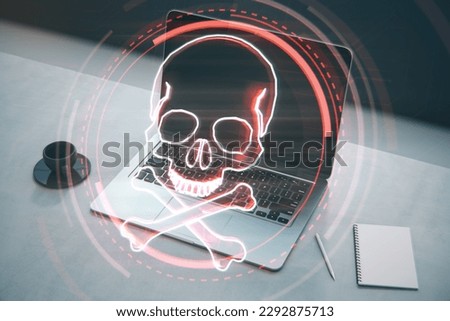 Close up of laptop, notepad and coffee cup on desktop with digital red skull on blurry background. Ransomeware, virus and pirate threat concept. Double exposure