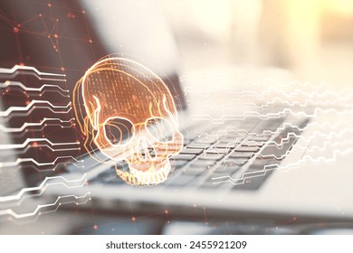 Close up of laptop on desk with creative skull and circuit hologram on blurry background. Malware and ransomware concept. Double exposure