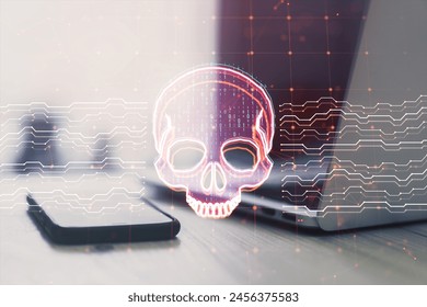 Close up of laptop and smartphone on desk with creative skull and circuit hologram on blurry background. Malware and ransomware concept. Double exposure