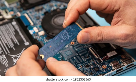 Close up laptop without cover inside disassembling in repair shop. Computer service engineer technician workplace repairing fixing broken components upgrade system, memory copy space
