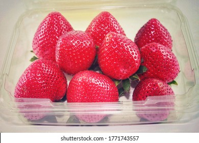 Close up of large ripe strawberries in an opened clear plastic box,red big size,freshness,and sweet fruit contain in packaging by vivid shade, isolated and vintage style,from a shop in supermarket.