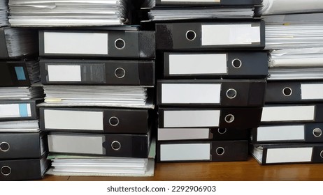 Close up large stack pile of file folders with paper documents in the office, business documents, messy, selective focus, filing, hardcopy