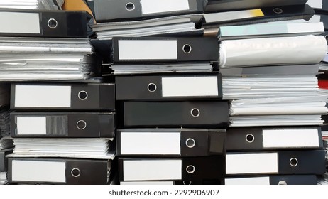 Close up large stack pile of file folders with paper documents in the office, business documents, messy, selective focus, filing, hardcopy