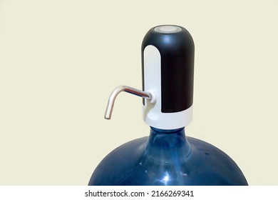 close up large transparent plastic, 19 liter gallon capacity, with drinking water and an electric pump installed using a battery with a dispenser. Isolation on a white background.