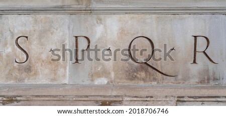 Close up of Latin inscription in a stone statue in Rome. SPQR is an initialism from a Latin phrase, Senatus Populusque Romanus, referring to the government of the ancient Roman Republic