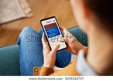 Close up of latin woman hand using smartphone to check the balance of her digital online wallet. Hispanic woman using mobile phone checking expenses of the month on smart phone by internet banking.